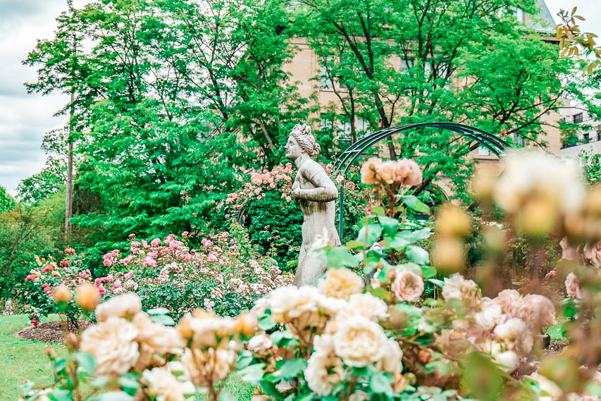 Flowers and greenery, with a sculpture, in Paris's botanical garden. 